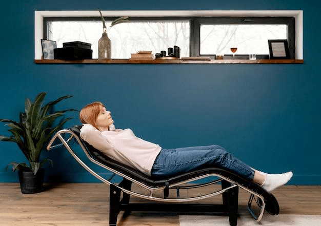 A lady relaxing indoors while sitting on a relaxing chair