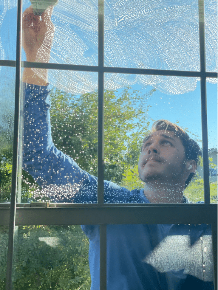 Man carefully cleaning a delicate window