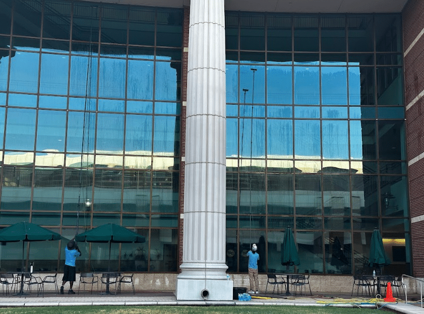 Professional window cleaners while cleaning a high-rise glass building facade